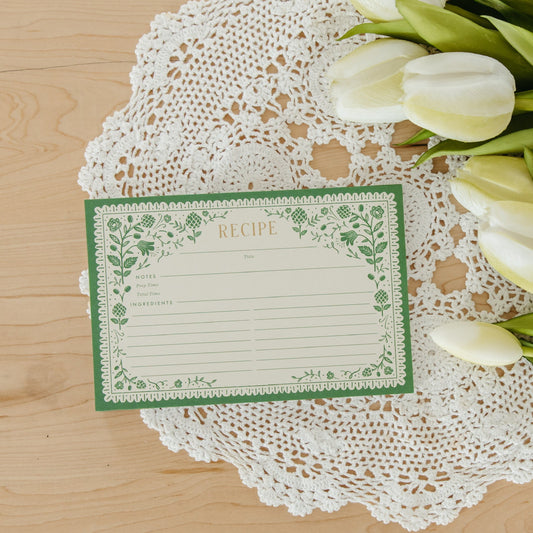 Recipe card with floral design on a lace doily with white tulips