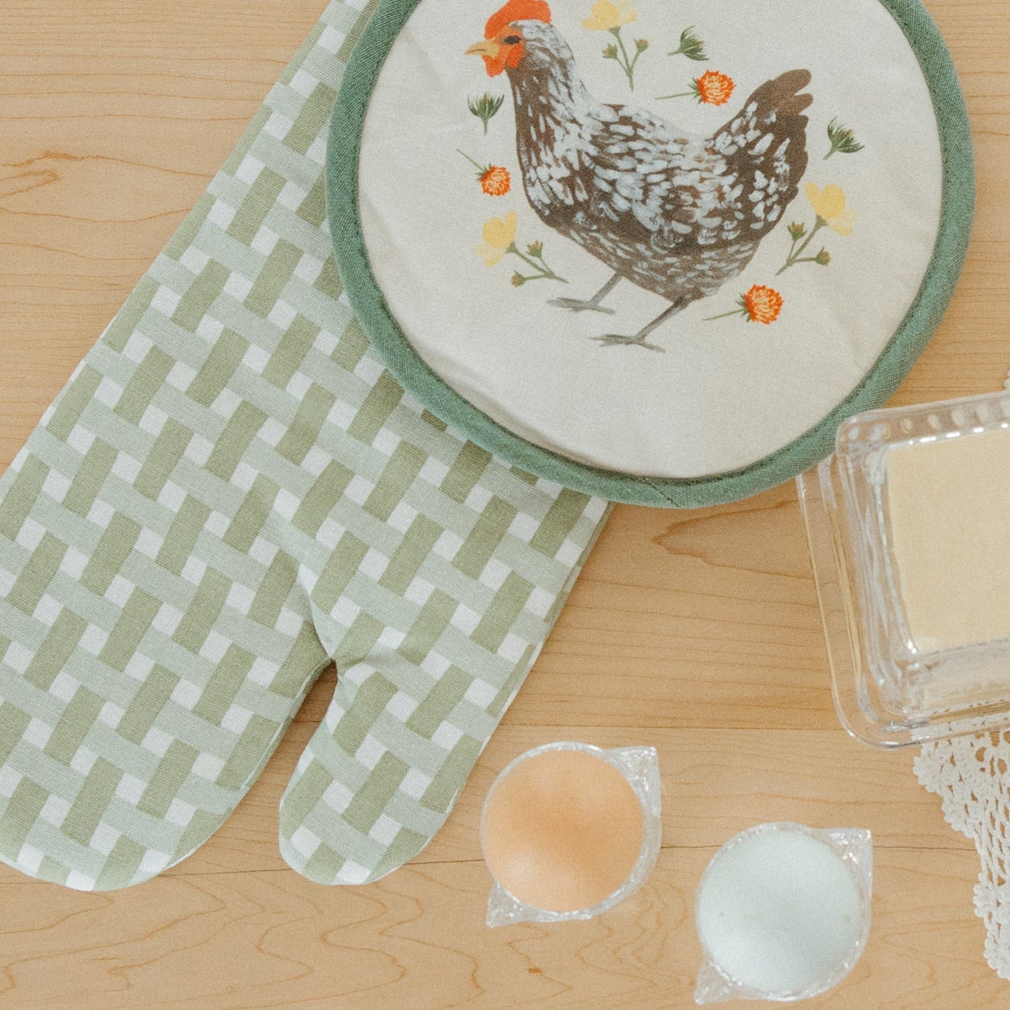 Butter and flowers on a wooden surface with decorative plates and doilies.