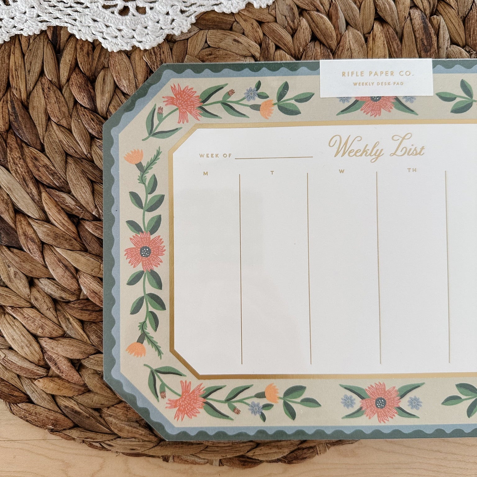 Floral-themed weekly planner on a woven surface